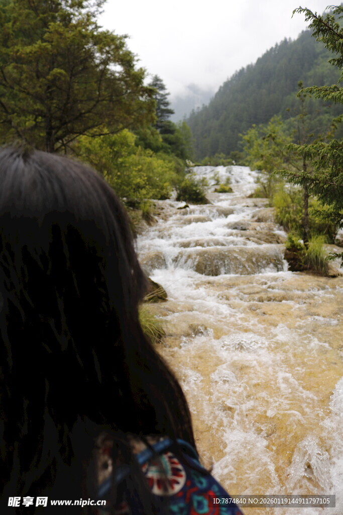 女子赏山间湍急溪流