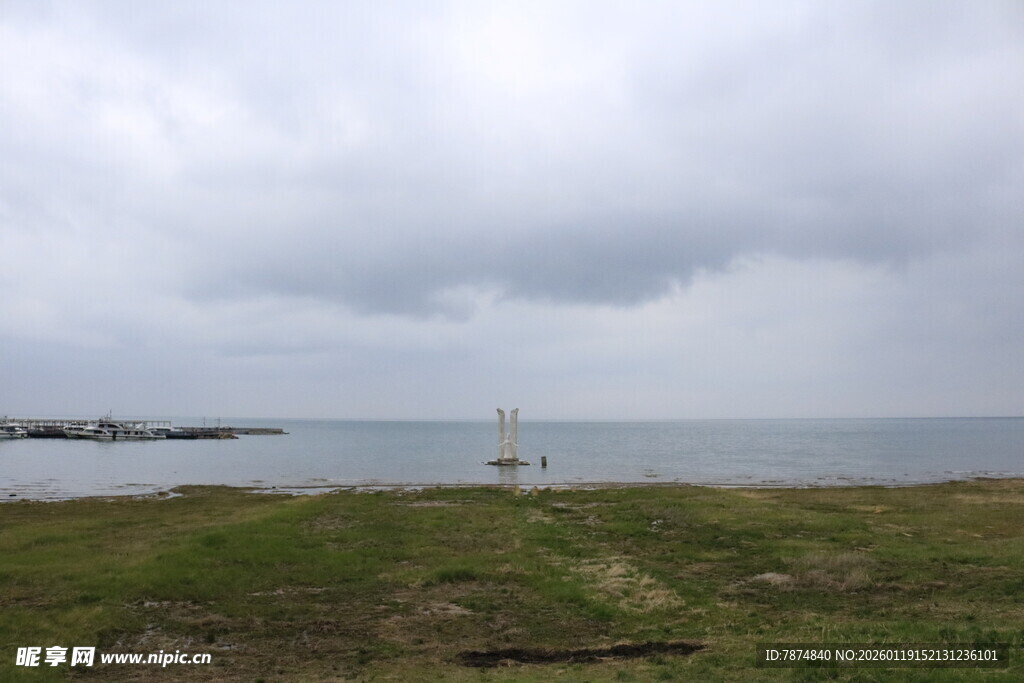 阴天海边草地与远处灯塔