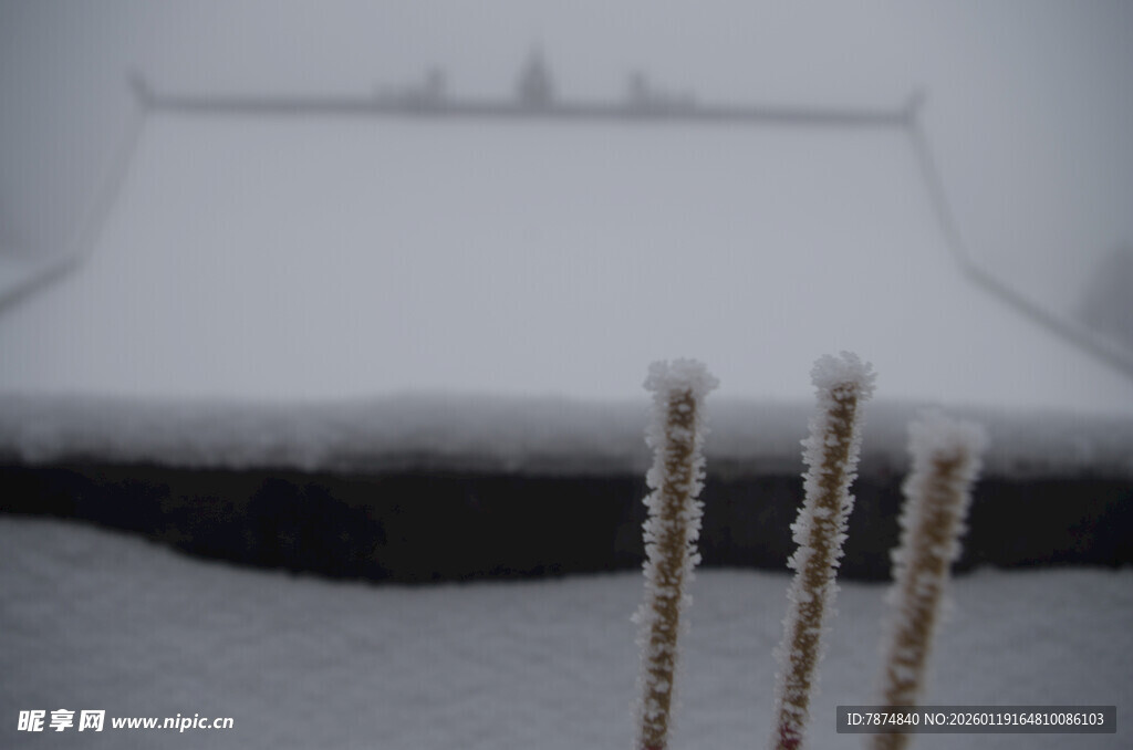 雪覆庙宇前的三根香