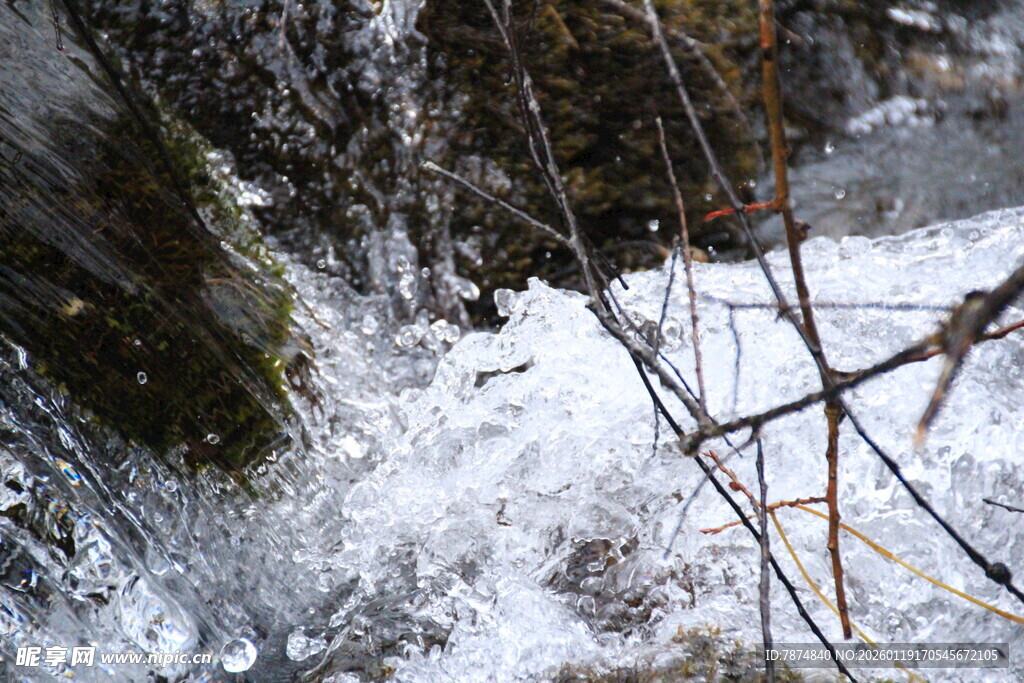 冬日溪边覆雪的冰凌与枝桠