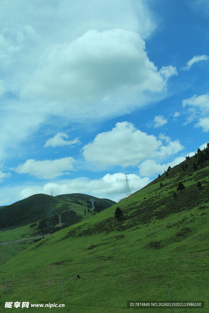 蓝天白云下的翠绿山坡