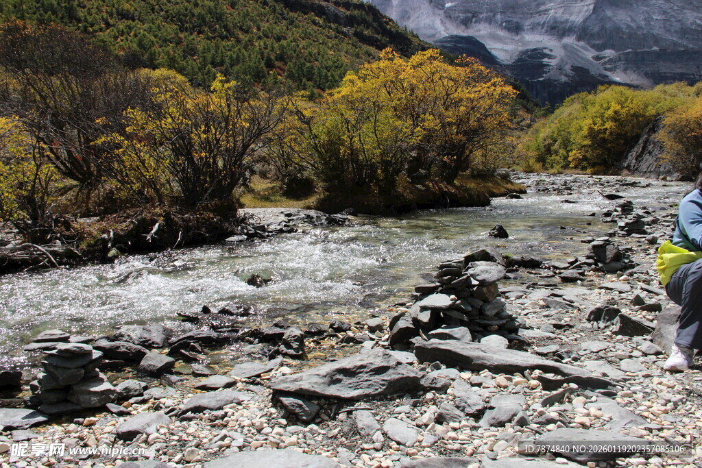 徒步者穿行于山间溪流旁