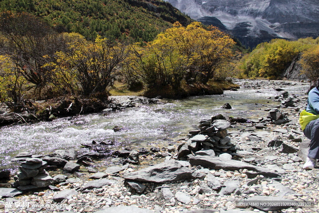 徒步者穿行于山间溪流旁