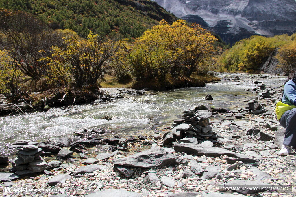 徒步者穿行于山间溪流旁