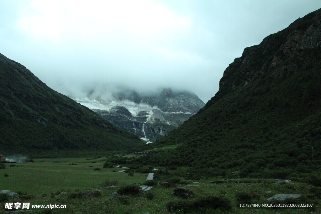 山间绿野与云雾中的雪山