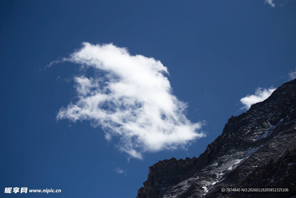 蓝天雪山旁的飘逸云朵
