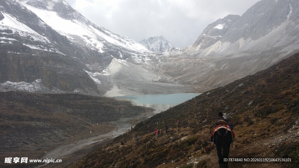 徒步者置身雪山湖泊美景中