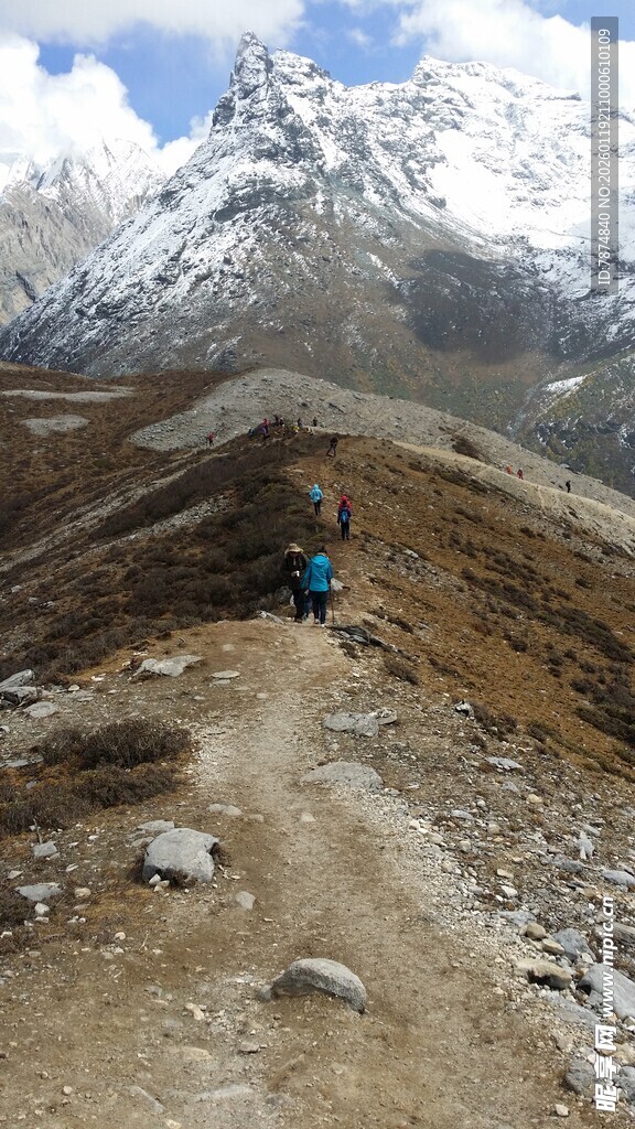 徒步者攀登雪山崎岖小径