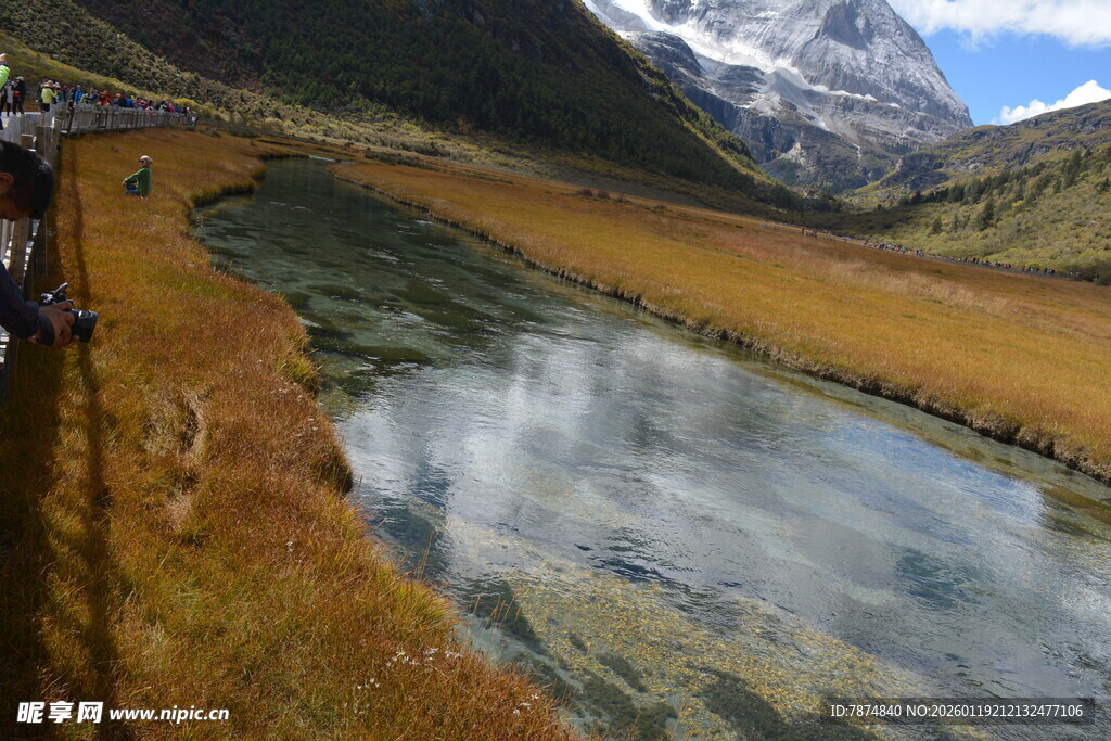 山间清澈溪流映雪山美景