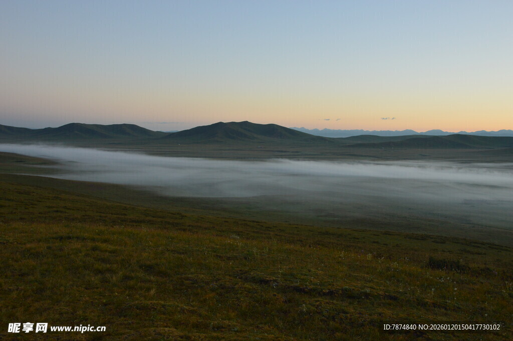 晨雾笼罩的草原与远山