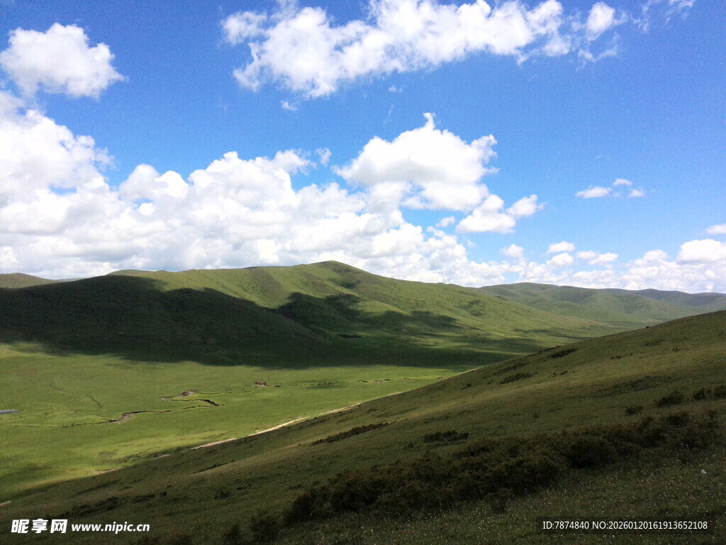 蓝天白云下的翠绿山丘