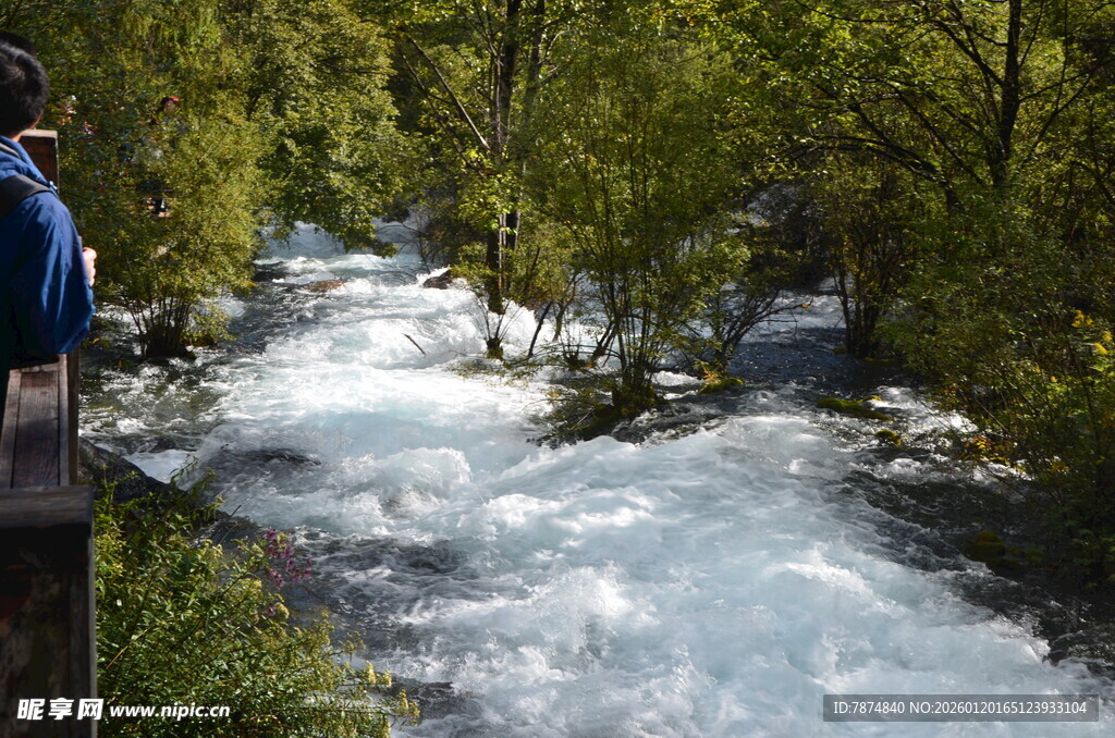 山间湍急溪流旁的观景者