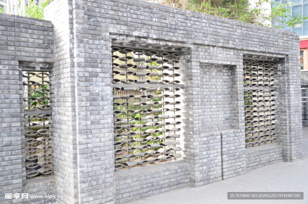 灰色镂空砖墙 绿植点缀