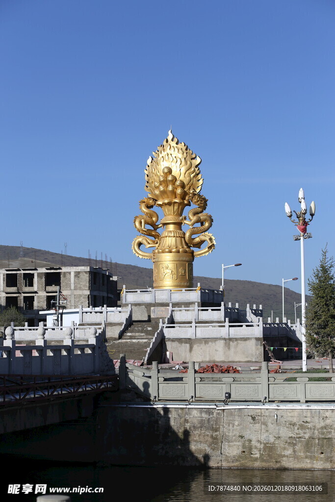 金色宏伟雕像立于水边