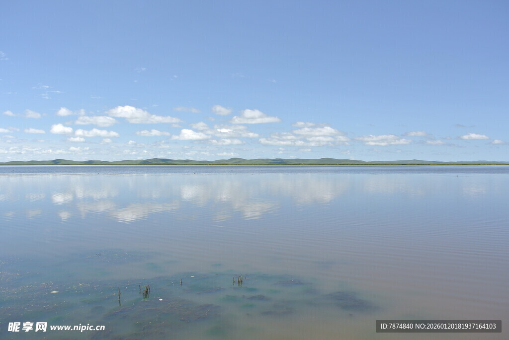 平静湖面映蓝天与白云