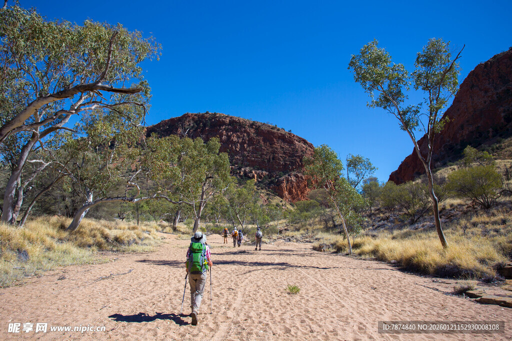 徒步者穿行于荒野岩石间