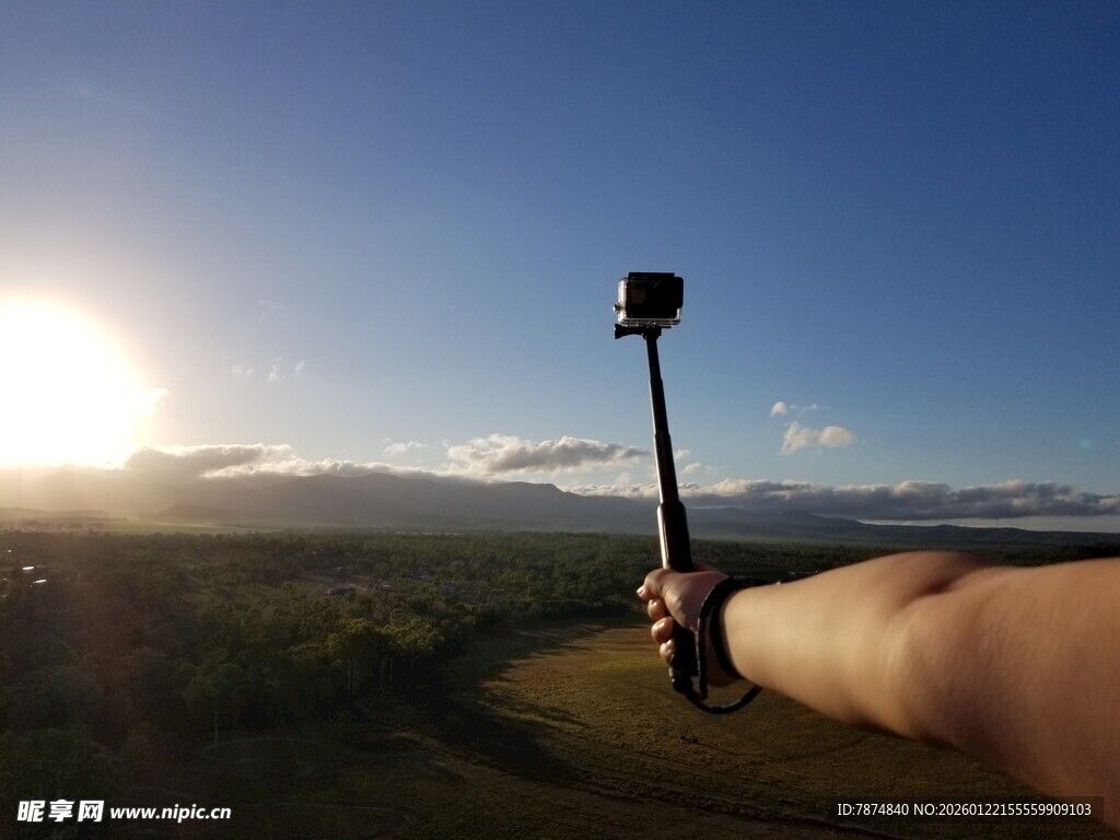 日出美景下的手持自拍杆