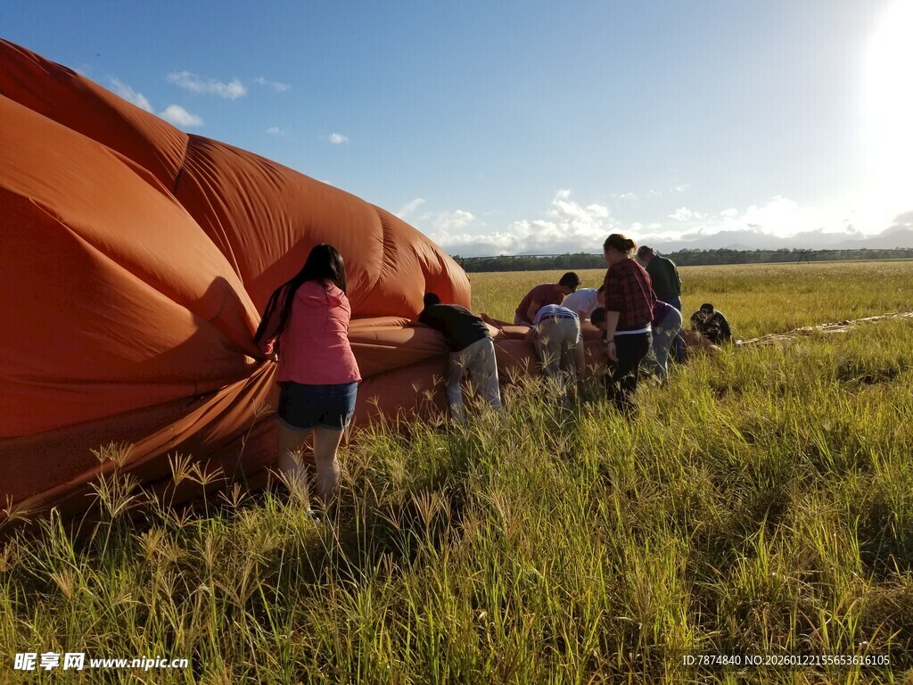 田野中众人操作大型橙色物