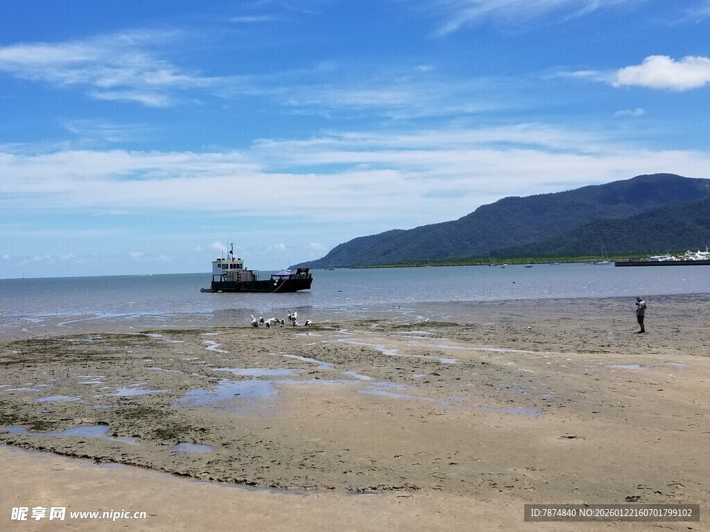海边沙滩上的船只与行人