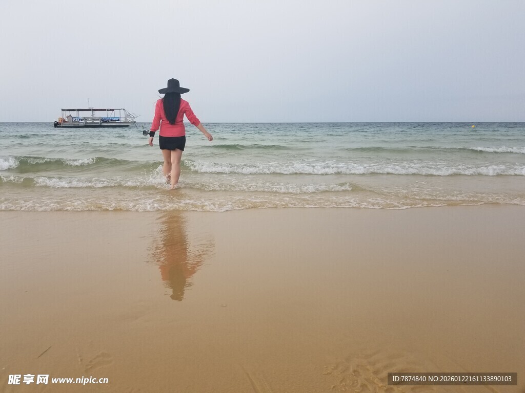 女子漫步于海边沙滩