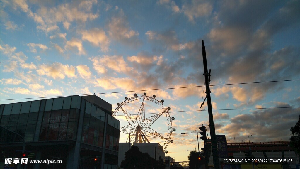 夕阳下的摩天轮与城市景象