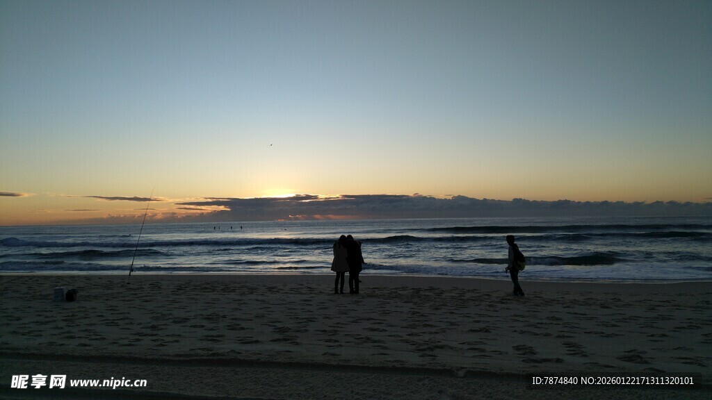 黄昏海滩上的漫步身影