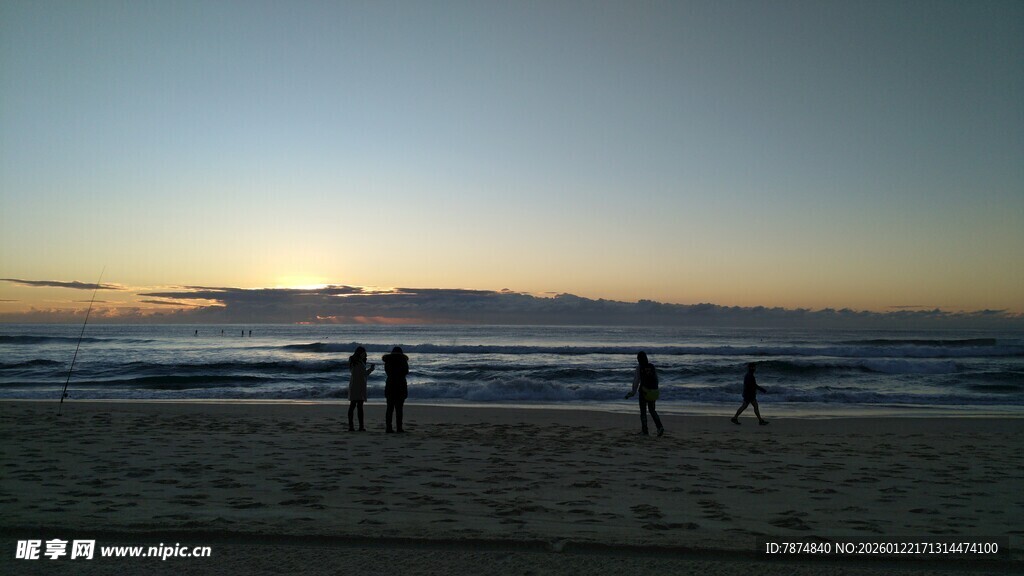 夕阳下的海边漫步身影