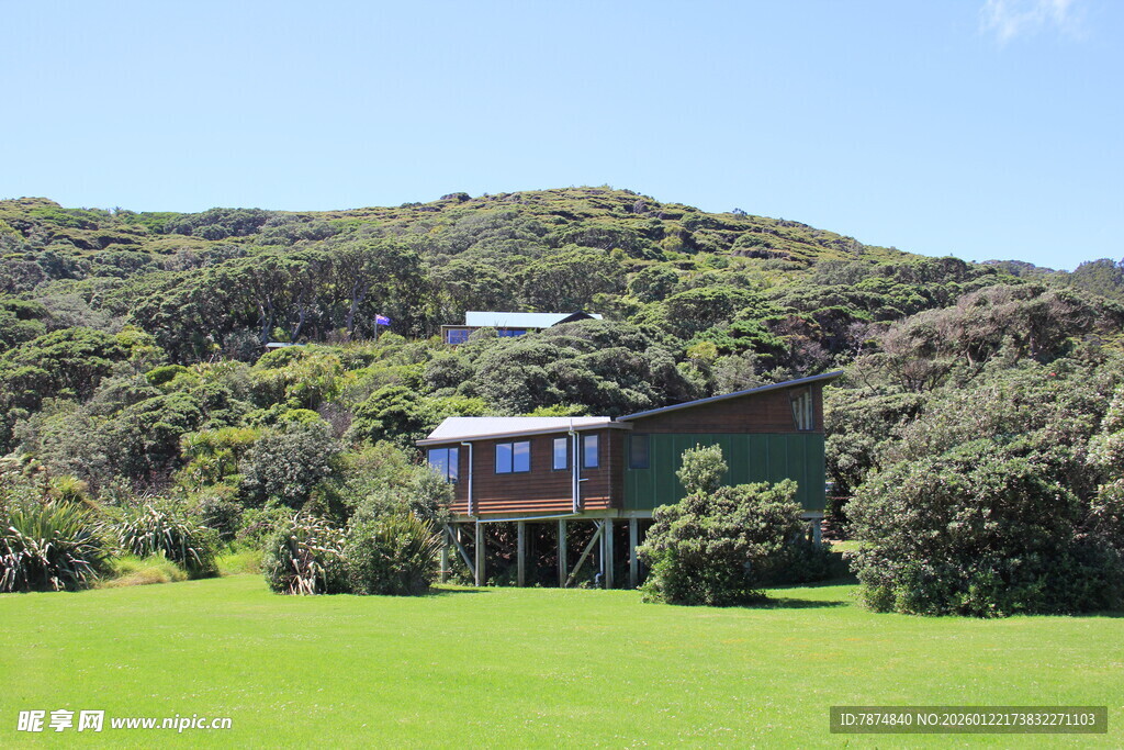 山间绿草地旁的精致小屋