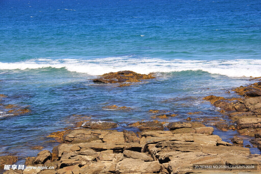 海边礁石与翻涌的蓝色海浪