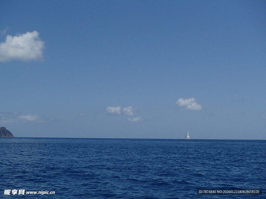 蔚蓝大海与远处白帆
