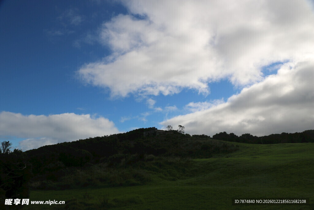 蓝天白云下的绿色山丘