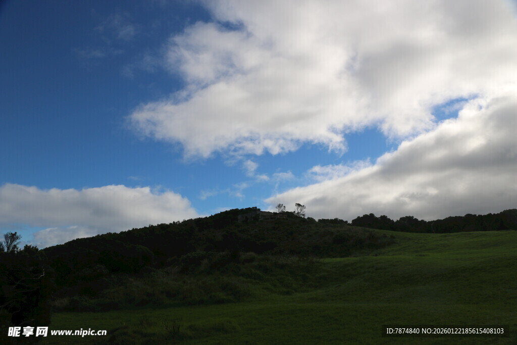 蓝天白云下的绿色山坡