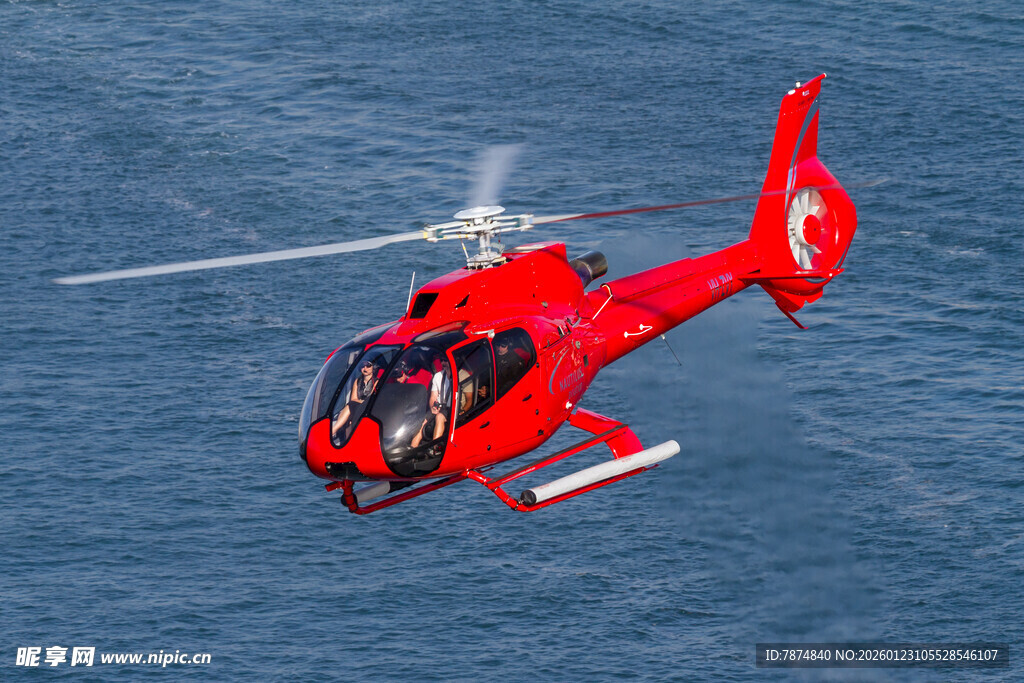 红色直升机翱翔于海面