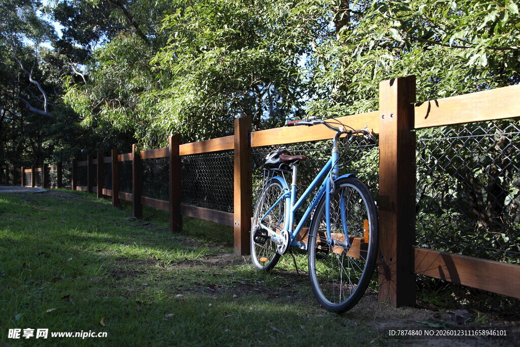 户外木栅栏旁的蓝色自行车