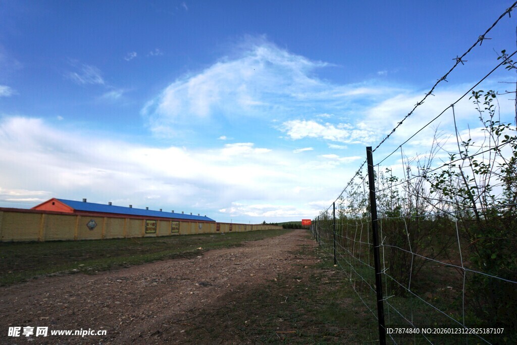 乡村土路旁的带刺铁丝网