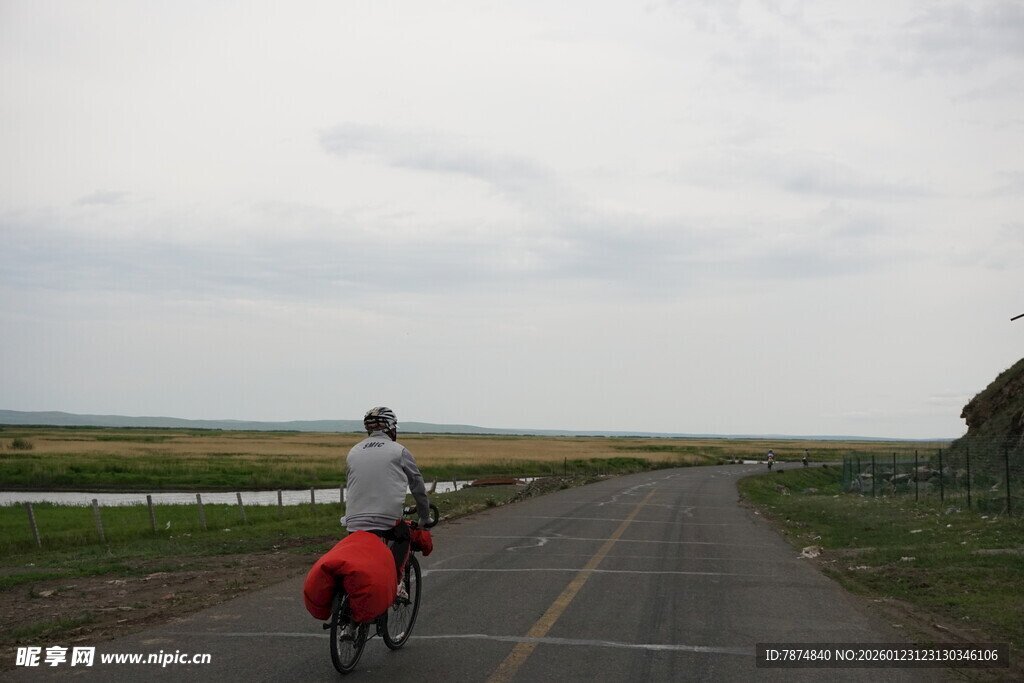 公路骑行者与红色驮包