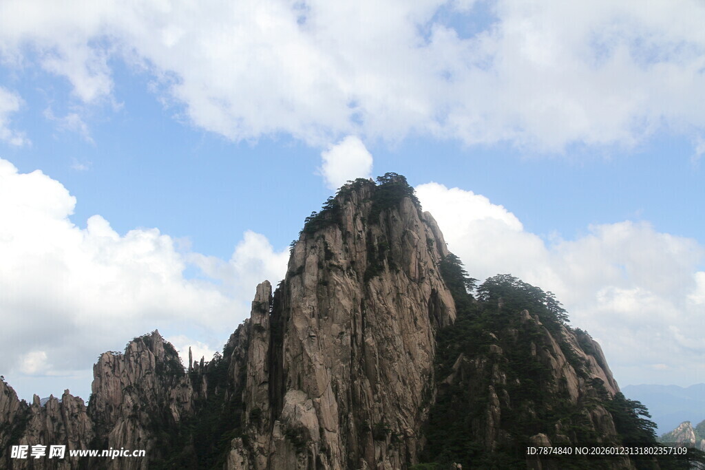 巍峨山峰耸立于蓝天白云间