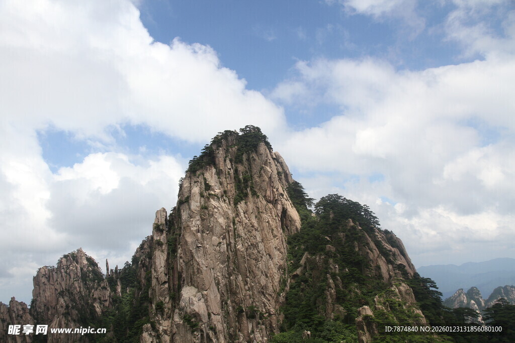 巍峨高山耸立于蓝天白云间