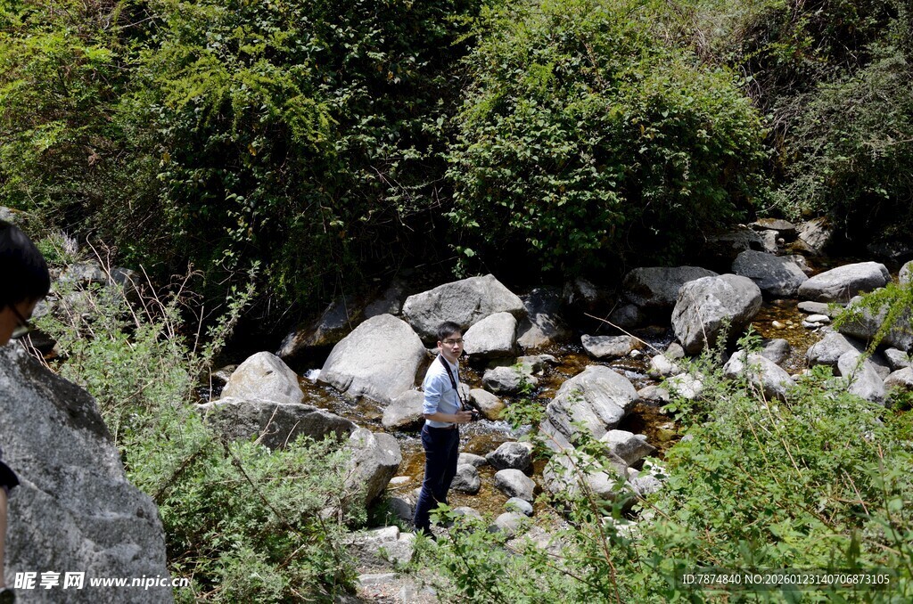山间徒步者与溪流岩石