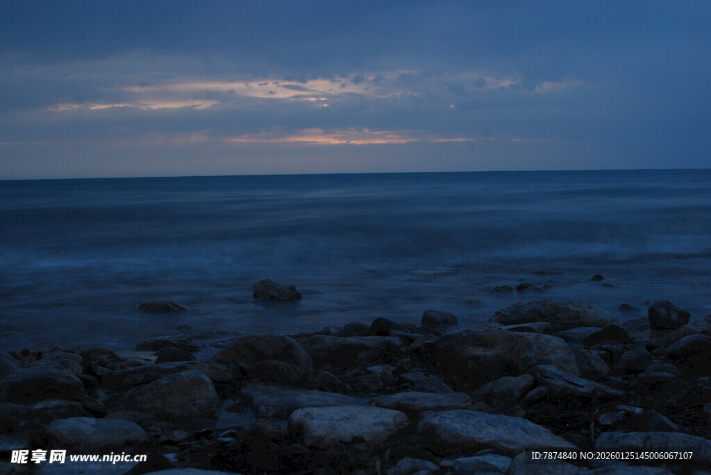 海边暮色下的礁石与海浪