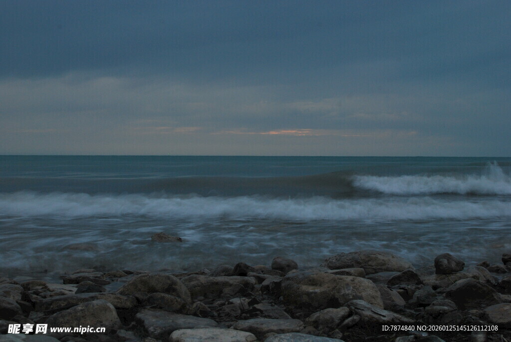 海边暮色下的礁石与海浪