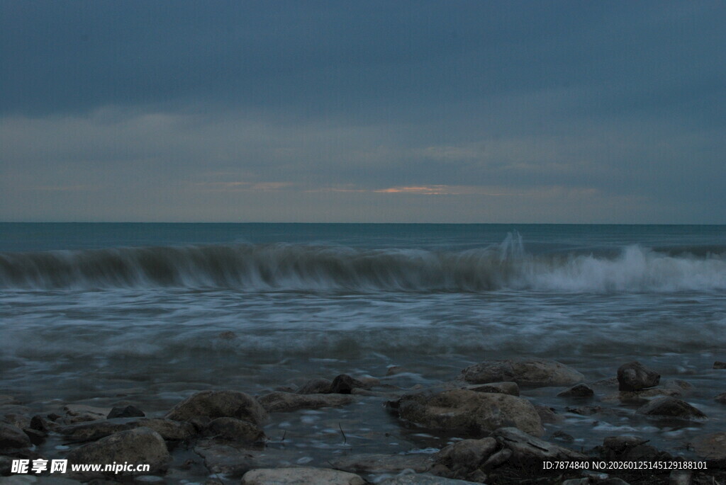 海边暮色下的礁石与海浪