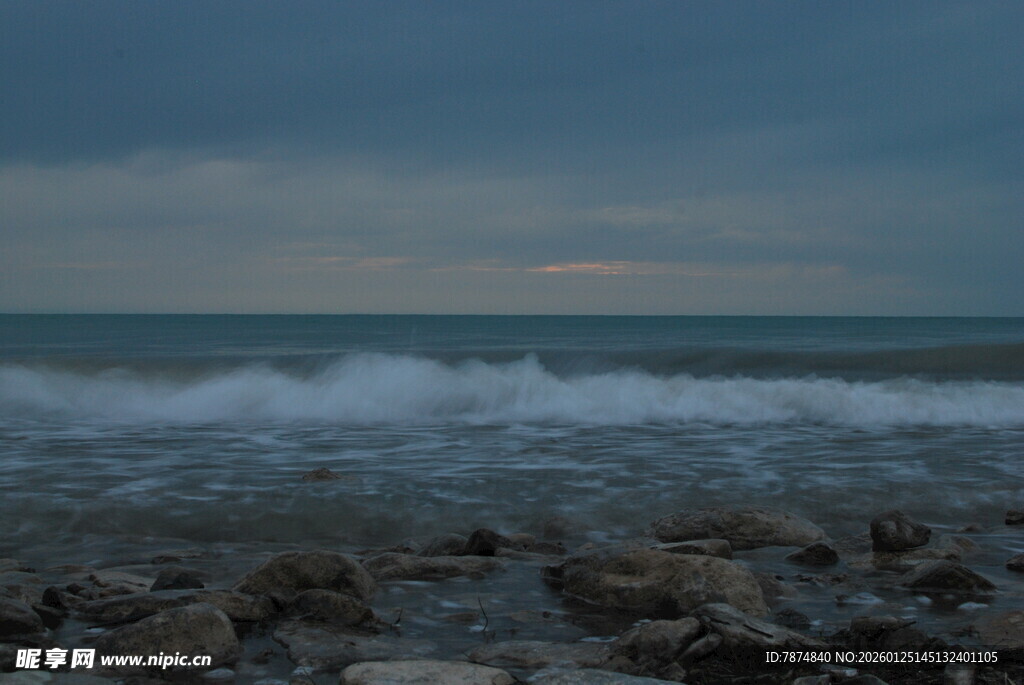海边暮色下的礁石与海浪