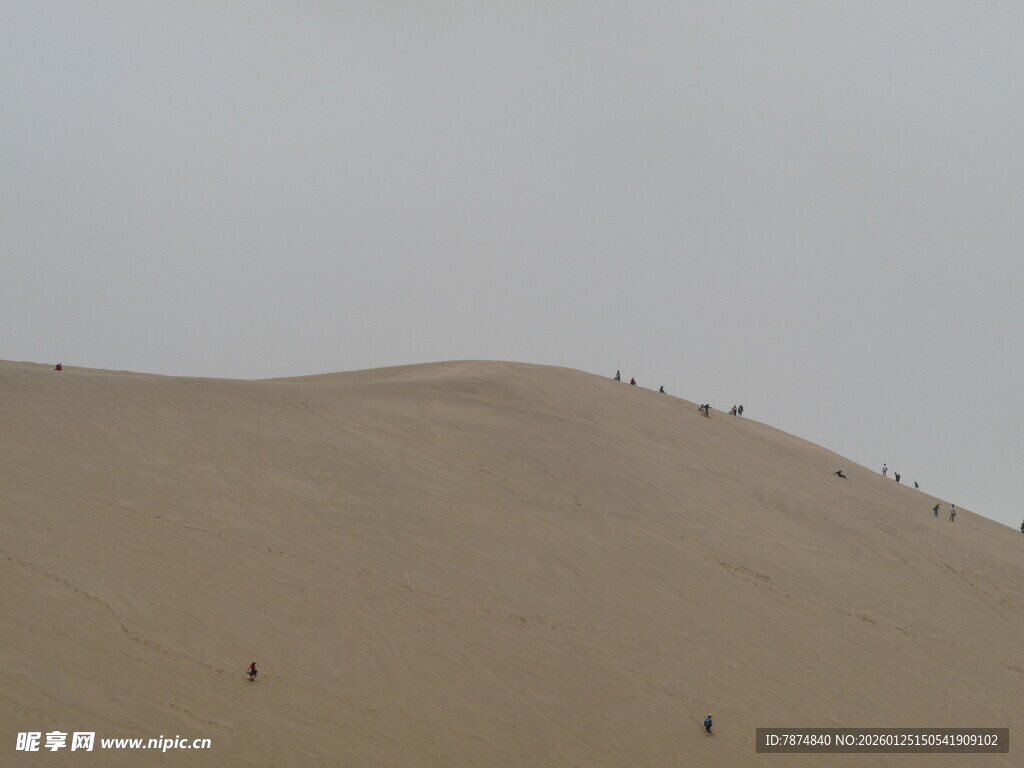 沙漠上人在沙丘上行走