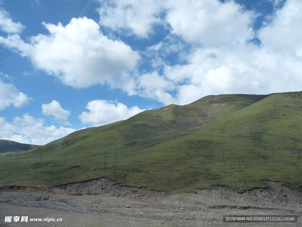 蓝天白云下的翠绿山坡