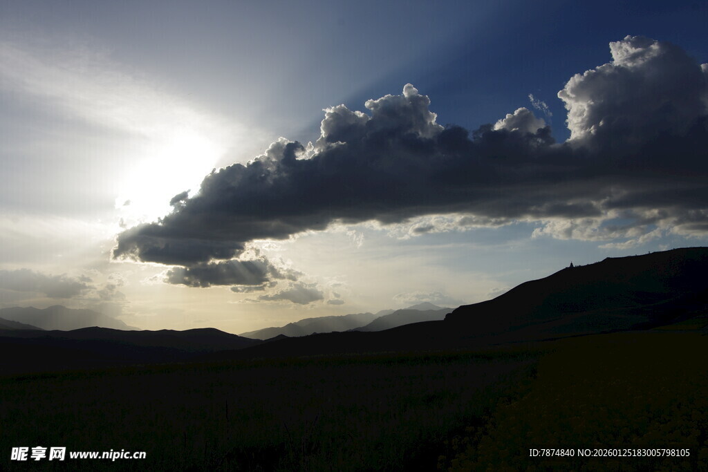 夕阳下的山峦与乌云