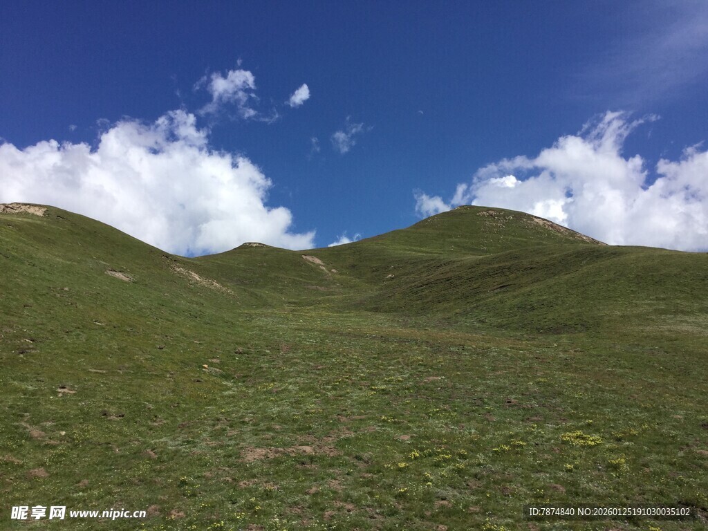 蓝天白云下的翠绿山丘