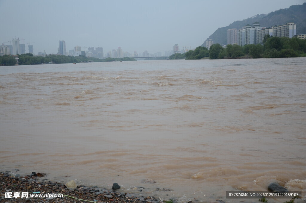 浑浊江水畔的城市与远山