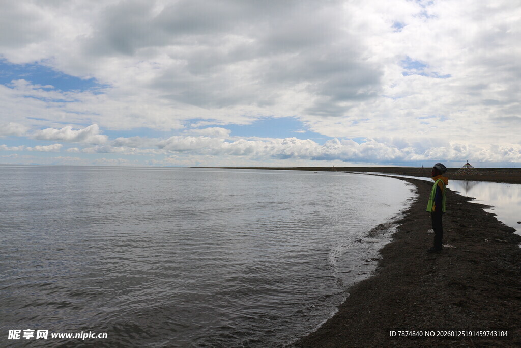 岸边一人赏辽阔水域