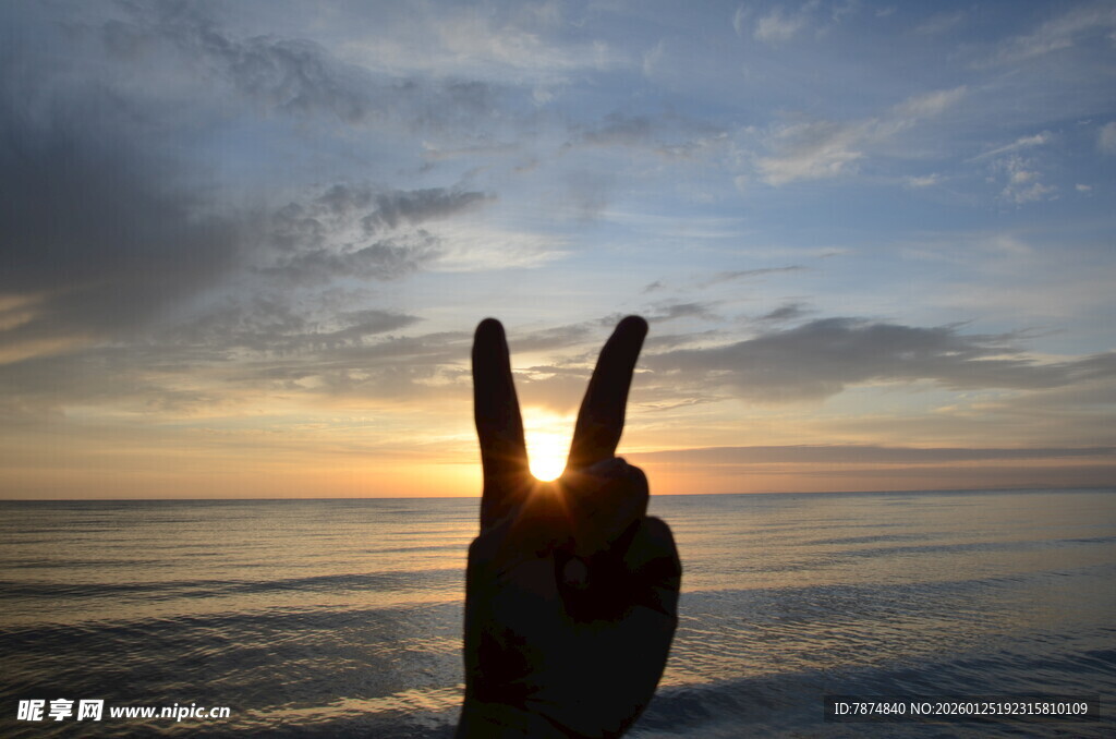 海边日落时的手势剪影